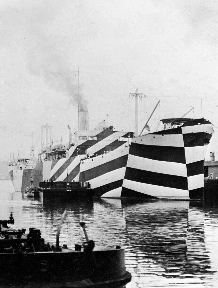 USS West Mahomet in port in 1918, its bow and hull painted with bold alternating dark and light diagonal bands.