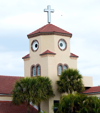 A church tower with circular windows and a projecting roof that can also resemble a chicken’s face.