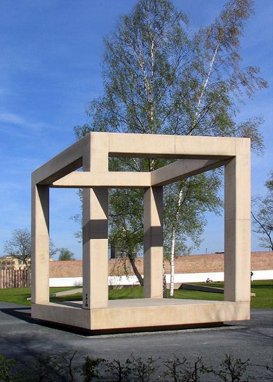 An outdoor sculpture whose separated frame elements resemble an impossible cube from this viewpoint.